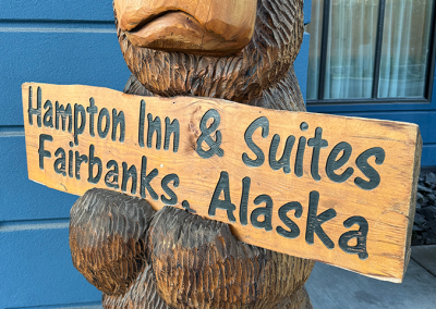 Carved wooden bear holding Hampton Inn sign in Fairbanks, Alaska